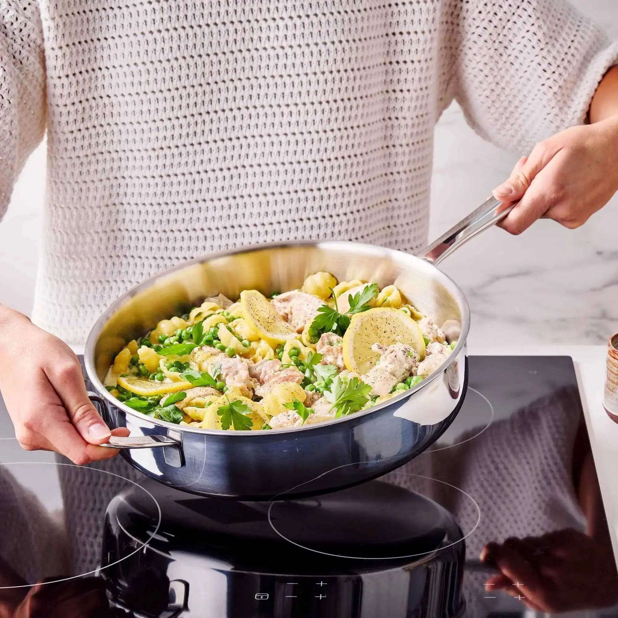 Alva stainless steel sauté pan serving pasta on induction