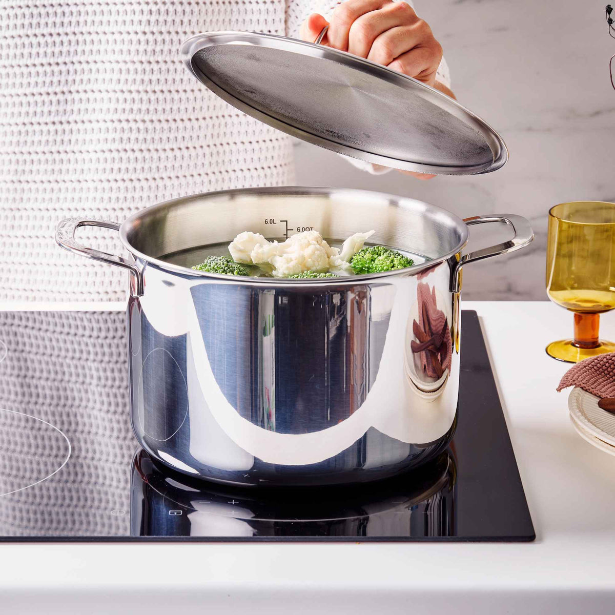 Alva Maestro 5-ply stainless steel stock pot with the lid ajar over steaming cauliflower and broccoli on a cooktop