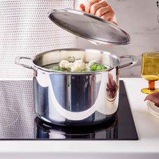 Alva Maestro 5-ply stainless steel stock pot with the lid ajar over steaming cauliflower and broccoli on a cooktop