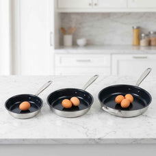 Alva Maestro frying pans in three sizes holding one, two and three eggs on a marble kitchen counter