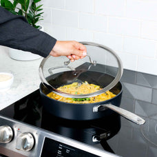 Lifting the glass lid off an Alva Maestro ceramic nonstick saute pan of pasta on an induction cooktop