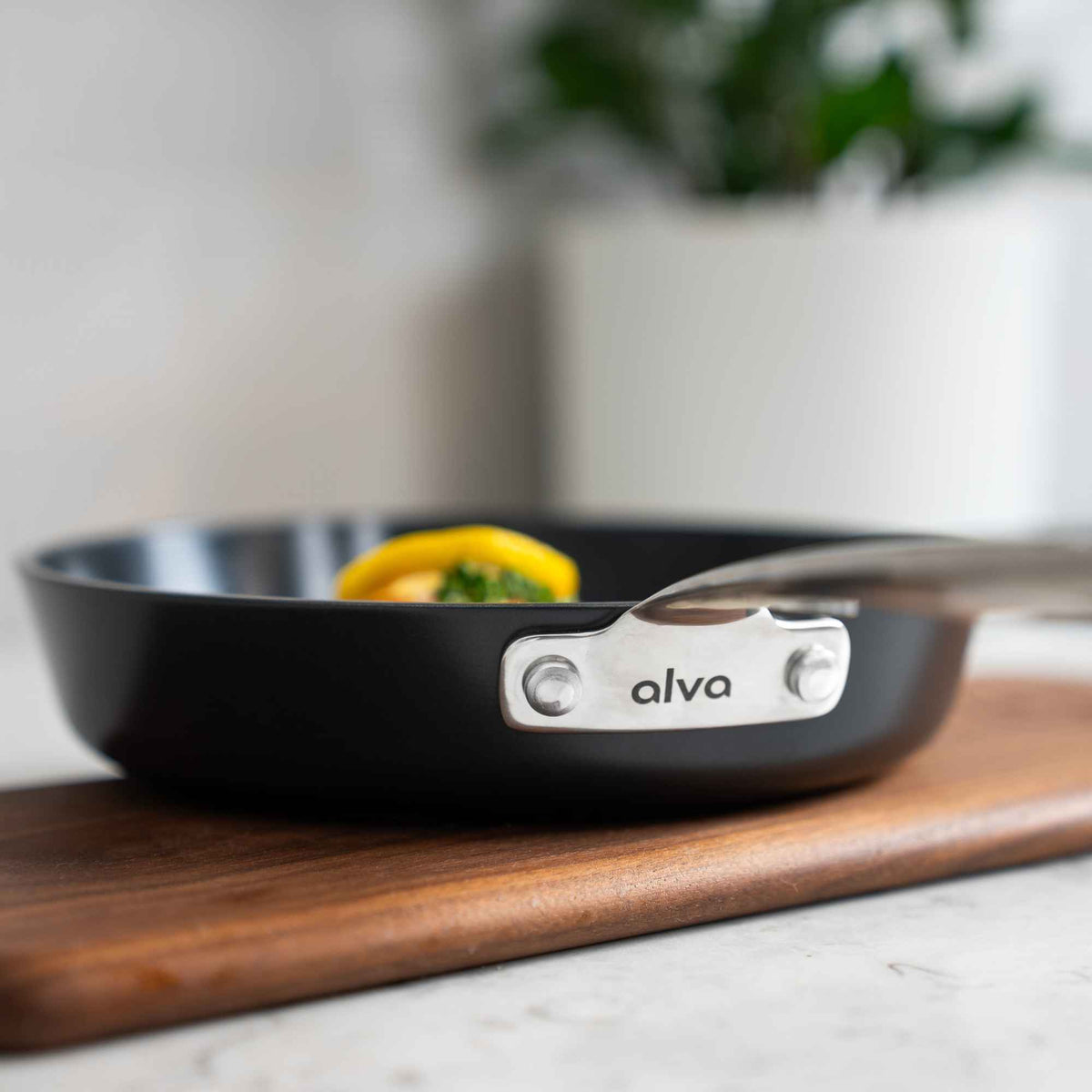 Close-up of the riveted stainless steel handle and alva logo on a Maestro ceramic nonstick frying pan
