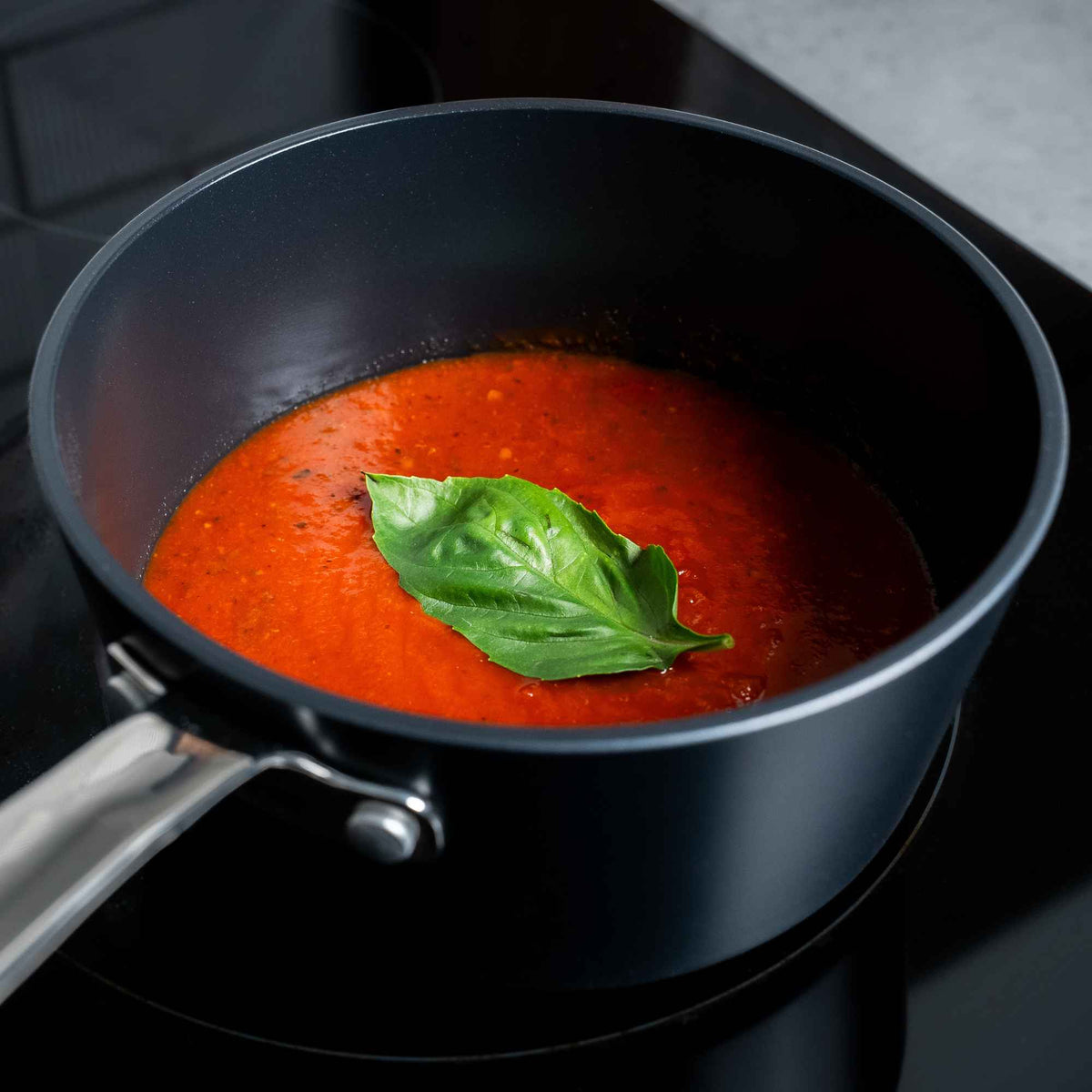 Close-up of tomato sauce with basil simmering in an Alva Maestro ceramic nonstick saucepan