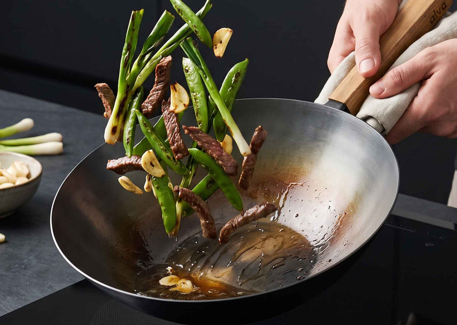 Alva Forest carbon steel wok tossing stir-fry vegetables