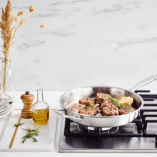 Alva stainless steel frying pan searing steak on a gas stovetop